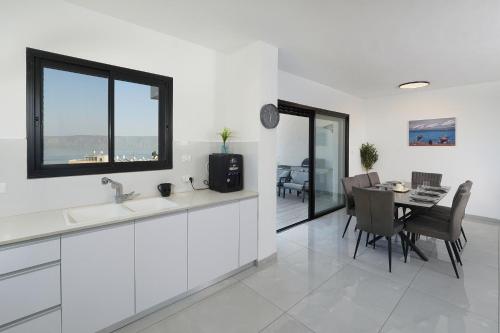 a kitchen and dining room with a table and chairs at לוי-קיישן מגוון דירות גן ופנטהאוזים וסוויטות נוף ברחוב הצנחנים in Tiberias