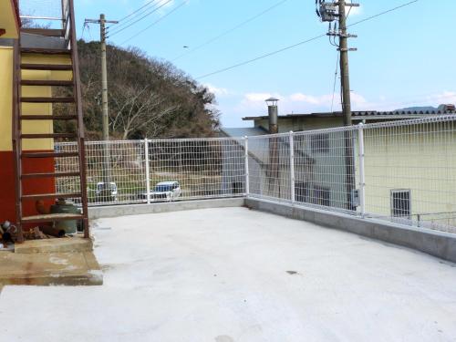a fence on the side of a building at 一棟貸切の宿 えんの家 in Tsushima