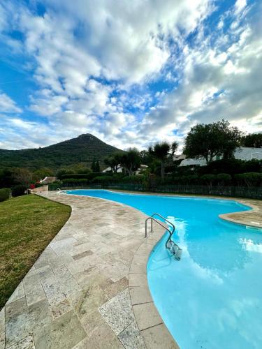 une grande piscine bleue avec un ciel nuageux dans l'établissement Mas rénové par un architecte, au Plan-de-la-Tour
