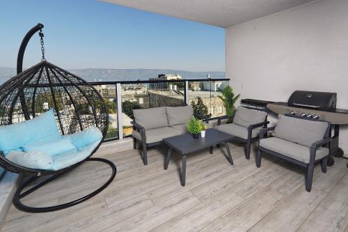 a room with chairs and a swing on a balcony at לוי-קיישן מגוון דירות גן ופנטהאוזים וסוויטות נוף ברחוב הצנחנים in Tiberias