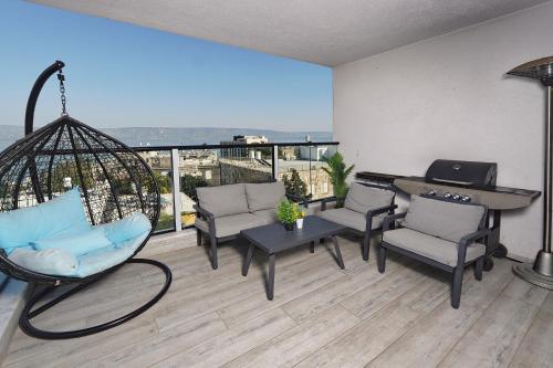 a balcony with chairs and a table and a swing at לוי-קיישן מגוון דירות גן ופנטהאוזים וסוויטות נוף ברחוב הצנחנים in Tiberias