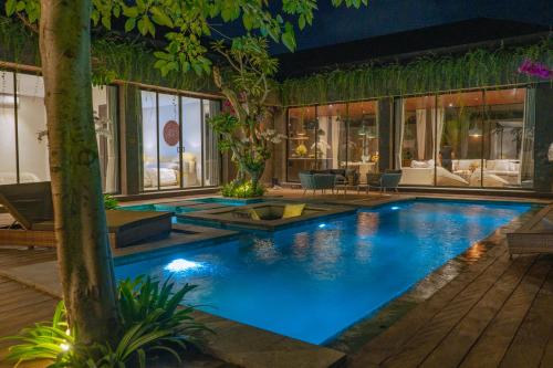 a swimming pool with blue water in a building at Villa Espresso Ubud in Sukawati