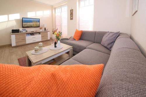 a living room with a couch and a tv at Exkl App Seestern, W-LAN, 250 m zum Strand in Börgerende-Rethwisch