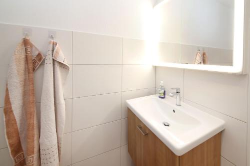 a white bathroom with a sink and a mirror at Exkl App Seestern, W-LAN, 250 m zum Strand in Börgerende-Rethwisch