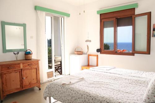a bedroom with a bed and a view of the ocean at Atlantis Rooms in Ágios Konstantínos