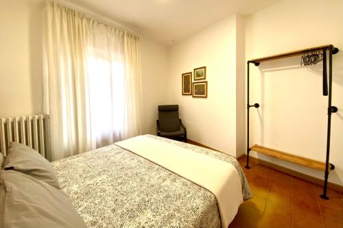 a bedroom with a bed and a chair and a window at PTHouse in Badia Prataglia