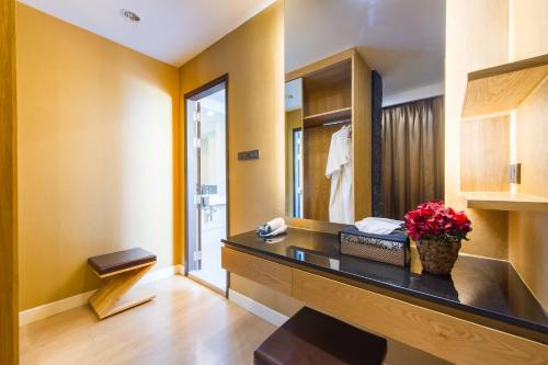 a bathroom with a desk with flowers on it at Zenniq in Bangkok