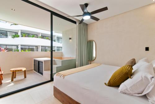 una camera con letto e balcone di Guest INN Home - Elements Suites a Tulum