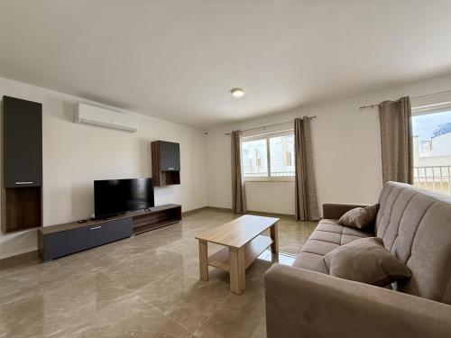 Una sala de estar con un sofá y un televisor de pantalla plana. en New Apartment! Walking distance to the three cities by SF Homes, en Fgura