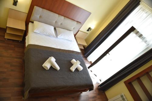 a hotel room with a bed with two towels on it at Yaffle Inn Shaki Boutique Hotel in Sheki