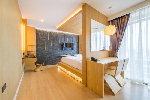 a bedroom with a bed and a desk and a television at Zenniq in Bangkok