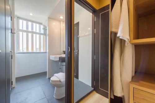 a small bathroom with a toilet and a window at Zenniq in Bangkok
