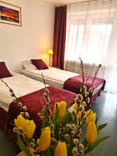 a hotel room with two beds with yellow tulips at Ośrodek Trzy Korony Krościenko nad Dunajcem in Krościenko