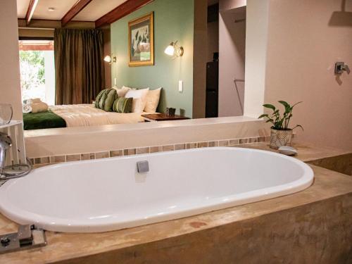 a large bath tub in a bathroom with a bed at Tranquility Town Stays in Winterton