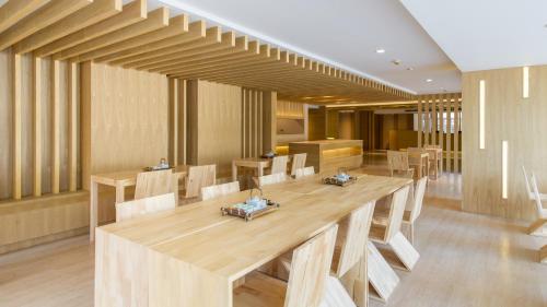 a dining room with a large wooden table and chairs at Zenniq in Bangkok
