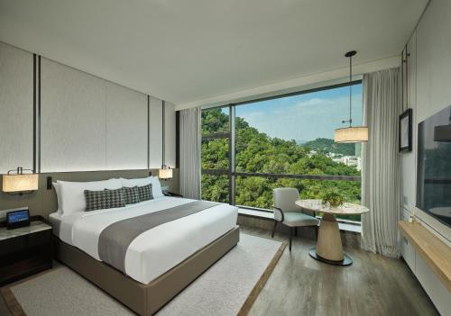 a bedroom with a large bed and a large window at Grand Ocean View Hotel Zhuhai in Zhuhai