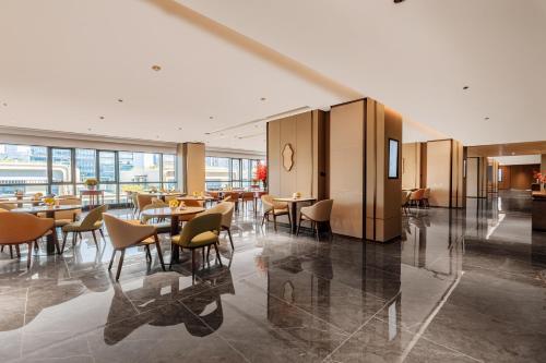 a restaurant with tables and chairs in a building at Holiday Inn Express Hangzhou Jiangnan by IHG in Hangzhou