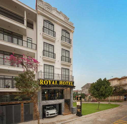 a hotel with a car parked in front of it at Royal Hotel Vinh Yen in Nhân Mỹ