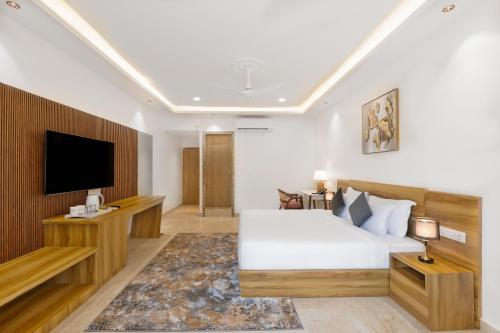 a bedroom with a bed and a flat screen tv at White Wharf Beach Resort Morjim Goa in Morjim