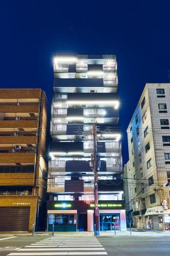 a tall building with lights on the side of it at Montana Wing Yebisu in Osaka