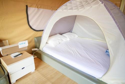 a small bed in a tent in a room at Dangjin Dogpelis Glamping in Dangjin