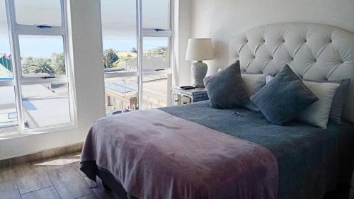 Un dormitorio con una cama grande con una ventana grande. en Bayview Manor, en Mossel Bay