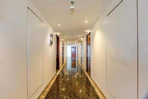 a hallway of a house with white walls and marble floors at The Chandra Leela Hotel in Indore