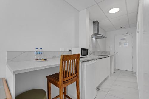 a kitchen with a wooden chair and a counter at Onehunga Suites in Auckland