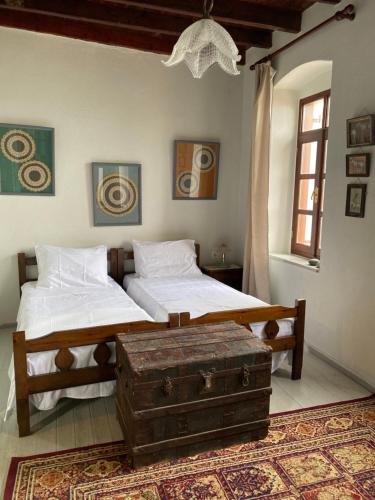 two beds in a room with a trunk on the floor at Home on the beach Vastadi in Mandrákion