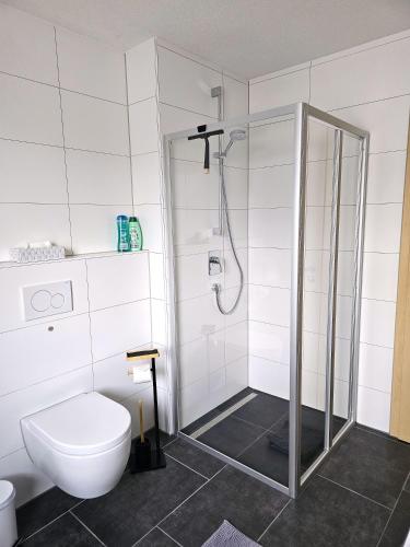 a white bathroom with a shower and a toilet at MY HOME 35 Nr 9 in Villingen-Schwenningen