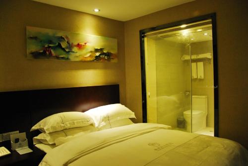 a bedroom with a bed and a bathroom with a shower at Slowcom┃Yuebei Hotel （Guangzhou Provincial Government) in Guangzhou