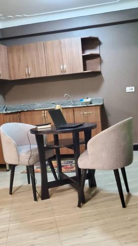 a desk with a laptop on it and a chair at Blaize Affaire Apartments in Kampala