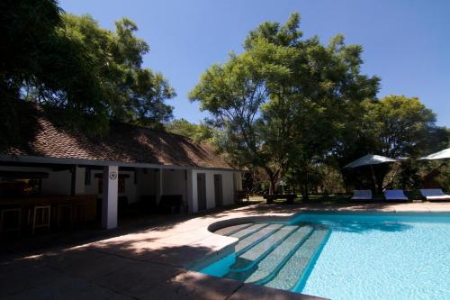 a swimming pool in front of a house at Au Bois Vert - Hôtel Ivato Airport in Ambohijanahary