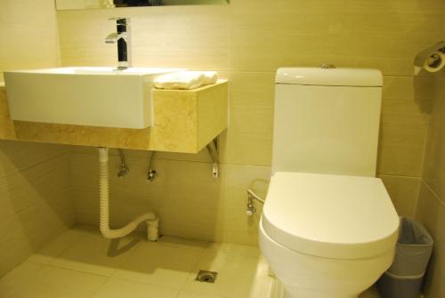a bathroom with a white toilet and a sink at Slowcom┃Yuebei Hotel （Guangzhou Provincial Government) in Guangzhou