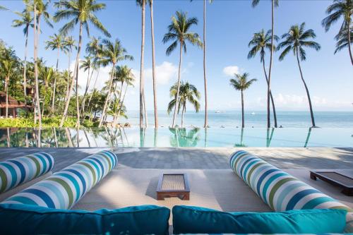 a view of the ocean from a resort with palm trees at Four Seasons Resort Koh Samui in Mae Nam