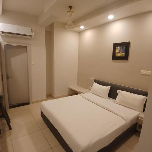 a bedroom with a large white bed with white pillows at Hotel Square 36 in Kota