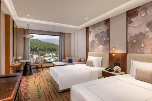 a hotel room with two beds and a view at Taj Mussoorie Foothills, Dehradun in Dehradun