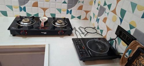 a stove on a counter with two cups at Suhana Aangan Homestay in Tirupati