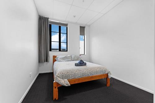 a bedroom with a bed in a room with a window at Onehunga Suites in Auckland