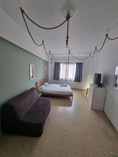 una camera da letto con un letto, un divano e una TV di athens.apartotel.2 ad Atene