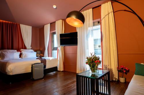 a hotel room with two beds and a table with flowers at Casa Suzanna Hotel Tel-Aviv קאסה סוזנה נחלת בנימין in Tel Aviv