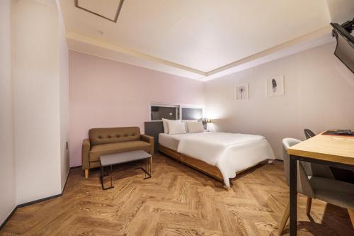 a hotel room with a bed and a chair at No25 Hotel Ansan in Ansan