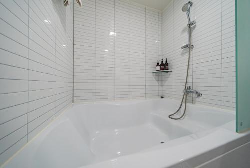 a white bathroom with a shower and a tub at No25 Hotel Ansan in Ansan