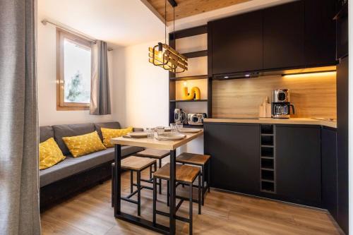 une cuisine et un salon avec un canapé et une table dans l'établissement Renovated Design Apartment with Slopes View Méribel Mottaret, à Les Allues