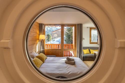 une chambre avec un lit et un miroir dans l'établissement Renovated Design Apartment with Slopes View Méribel Mottaret, à Les Allues