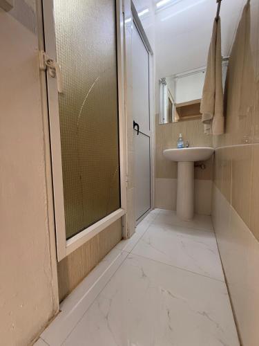 a bathroom with a glass shower and a sink at Cosy Two-Bedroom Apartment in Port Louis