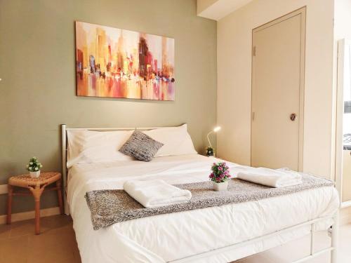 a bedroom with a white bed with a painting on the wall at F1-33-13 Sweet Home5,1BRTamarindWiFiNetflixFreeParking in Cyberjaya