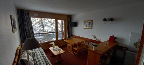 a room with a bed and a desk and a window at Les Arcs 1800 Ruitor in Arc 1800