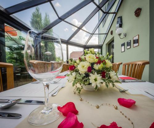 a table with a wine glass and a vase of flowers at Pavilon in Ricany