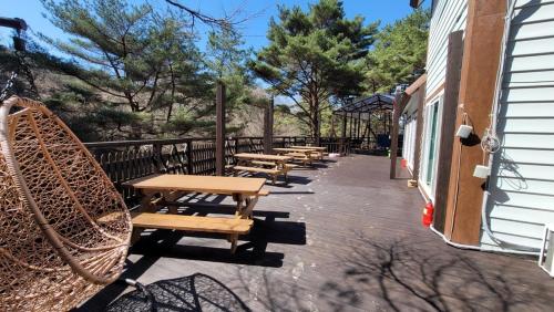 a row of wooden benches sitting on a patio at Namwon Along the Waterways of Jiri Mountain in Namwon